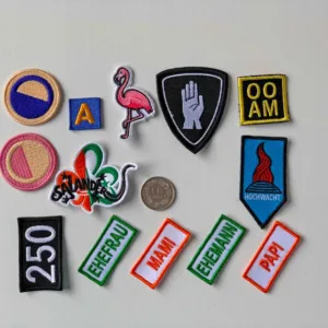 Variety of embroidered patches, including designs such as a flamingo, hand symbol, and various text patches in different colors.