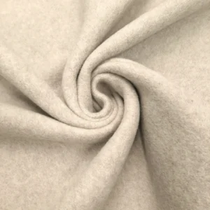 Close-up of folded cream-colored custom clothing fabric texture